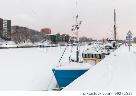 Small boats are moored at Aura river coast on a winter day. Turku 99251555