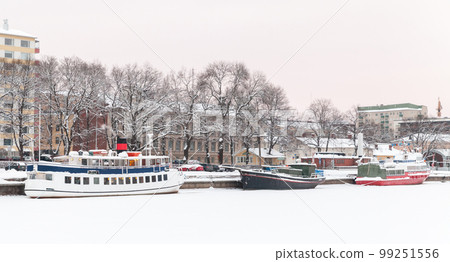 Small boats are moored at Aura river coast on a winter day in Turku Small boats are moored at Aura river coast on a winter day in Turku 99251556