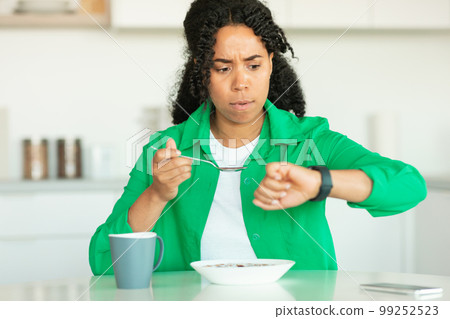 African American Lady Being Late Looking At Watch In Kitchen 99252523