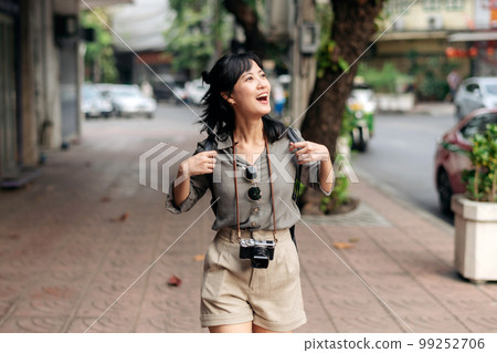 Young Asian woman backpack traveler enjoying street cultural local place and smile. Traveler checking out side streets. Young Asian woman backpack traveler enjoying street cultural local place and smile. Traveler checking out side streets. 99252706
