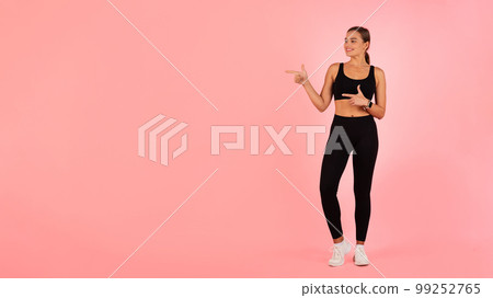 Look There. Smiling Young Female In Sportswear Pointing At Copy Space 99252765