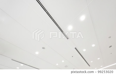 Ceiling mounted cassette type air conditioner and modern lamp light on white ceiling. duct air conditioner for home or office Ceiling mounted cassette type air conditioner and modern lamp light on white ceiling. duct air conditioner for home or office 99253020
