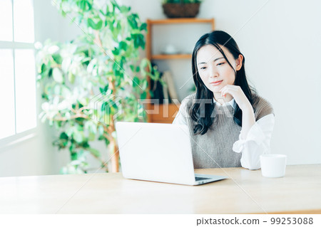 做遠程辦公的一個少婦在客廳。 99253088