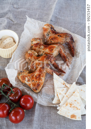 Ready spicy grilled chicken wings with greens and tomato Ready spicy grilled chicken wings with greens and tomato 99253457