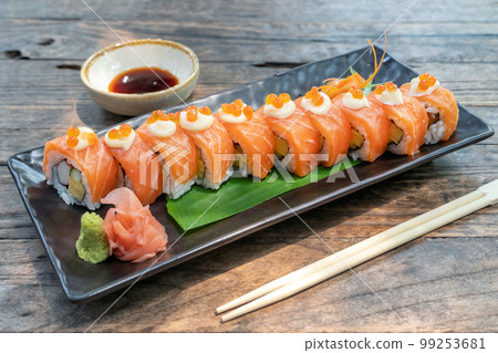 Japanese food. Roll with salmon, avocado, cottage cheese and cucumber. Serving dishes in a restaurant 99253681