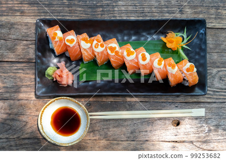 Japanese food. Roll with salmon, avocado, cottage cheese and cucumber. Serving dishes in a restaurant 99253682