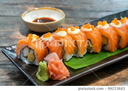Japanese food. Roll with salmon, avocado, cottage cheese and cucumber. Serving dishes in a restaurant Japanese food. Roll with salmon, avocado, cottage cheese and cucumber. Serving dishes in a restaurant 99253683