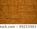 Old ochre yellow stone wall abstract background photo. 99253983