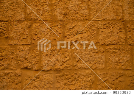 Old ochre yellow stone wall abstract background photo. Old ochre yellow stone wall abstract background photo. 99253983