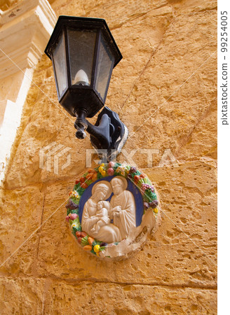 Traditional religious catholic bas-relief od Virgin Mary with baby Jesus near the building entrance in Mdina, Malta Traditional religious catholic bas-relief od Virgin Mary with baby Jesus near the building entrance in Mdina, Malta 99254005