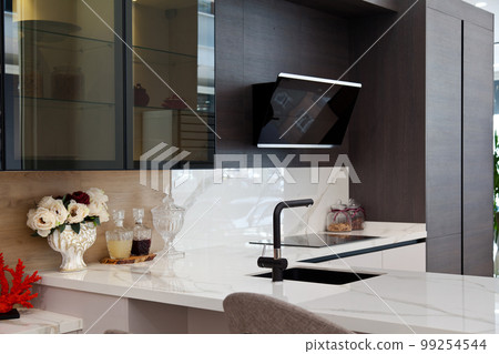 Modern gray and ash tree wood kitchen cabinet and black faucet on white granite countertop Modern gray and ash tree wood kitchen cabinet and black faucet on white granite countertop 99254544