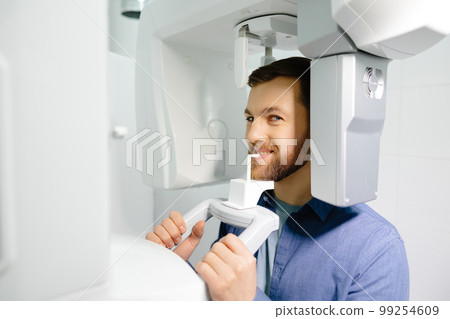 Panoramic image of teeth. A patient in a modern dental clinic takes a panoramic picture of the teeth. Prevention of dental diseases. Accurate diagnosis. 99254609