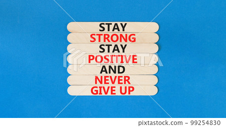 Never give up symbol. Concept words Stay strong stay positive never give up on wooden stick. Beautiful blue table blue background. Copy space. Motivational business never give up concept. 99254830