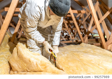 cutting glass wool when insulating the ceiling on the roof 99257989