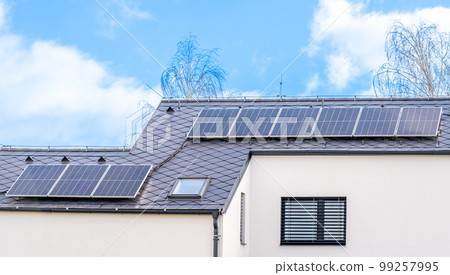 solar panels for the production of electricity from the sun on the roof of a family house 99257995