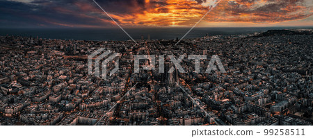 Aerial view of Barcelona City Skyline and Sagrada Familia Cathedral at sunset. Eixample residential famous urban grid. Cityscape with typical urban octagon blocks 99258511