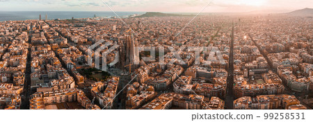 Aerial view of Barcelona City Skyline and Sagrada Familia Cathedral at sunset. Eixample residential famous urban grid. Cityscape with typical urban octagon blocks Aerial view of Barcelona City Skyline and Sagrada Familia Cathedral at sunset. Eixample residential famous urban grid. Cityscape with typical urban octagon blocks 99258531