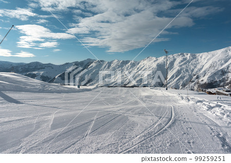 fresh cleaned ski track, top of snowy mountain at winter resort, clean blue sky  99259251