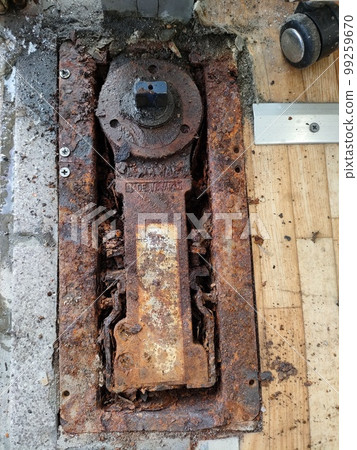 Old and rusty swing door floor hinge Old and rusty swing door floor hinge 99259670