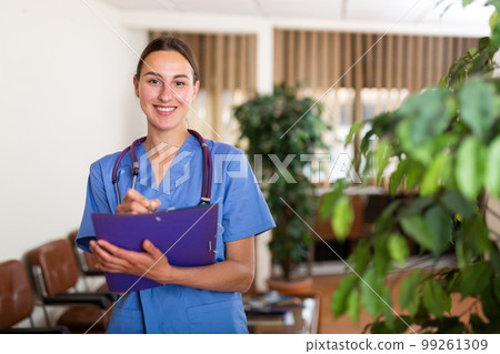 Portrait of a smiling young female doctor taking important work notes 99261309