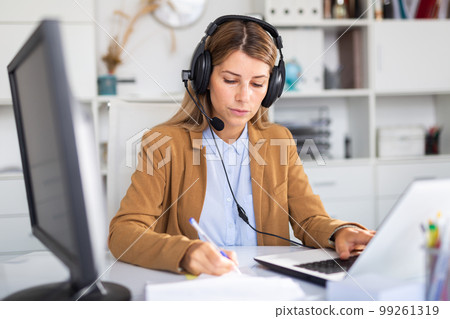 happy adult female operator working in white office happy adult female operator working in white office 99261319