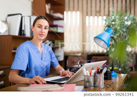 Woman doctor sitting at workplace with computer in office Woman doctor sitting at workplace with computer in office 99261341