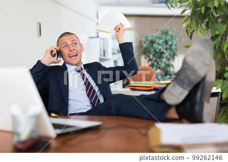 Positive man office worker talking on phone Positive man office worker talking on phone 99262146