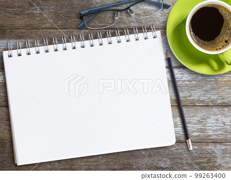 Top view blank notebook,glasses and coffee on wood table background on office desk. Top view blank notebook,glasses and coffee on wood table background on office desk. 99263400