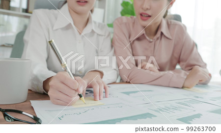 Two young enthusiastic businesswoman working together in the office workspace. 99263700