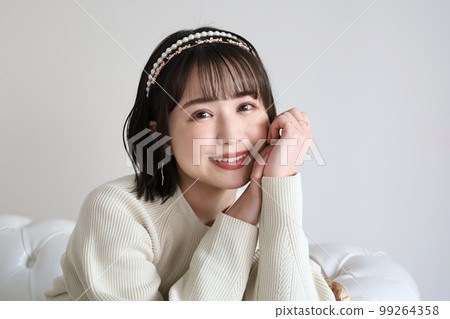 A woman smiling at the sofa 99264358