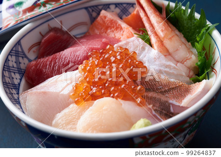 Bowl of rice topped with sashimi  99264837