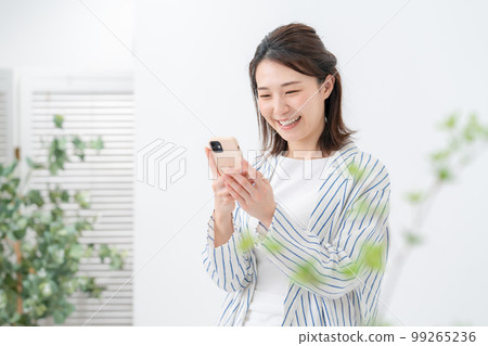 A woman operating a smartphone 99265236