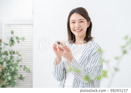 A woman operating a smartphone 99265237