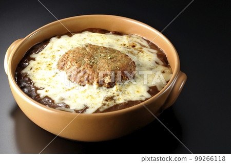 A grilled curry with plenty of cheese and hamburger on a black background A grilled curry with plenty of cheese and hamburger on a black background 99266118