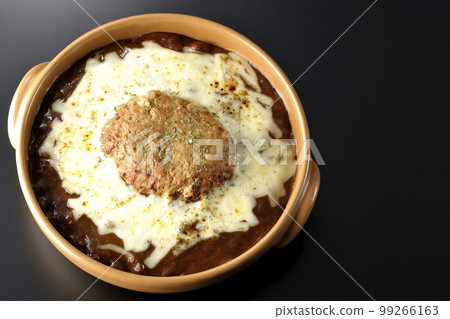 A bird's-eye view shot of grilled curry with plenty of cheese and hamburger on a black background 99266163