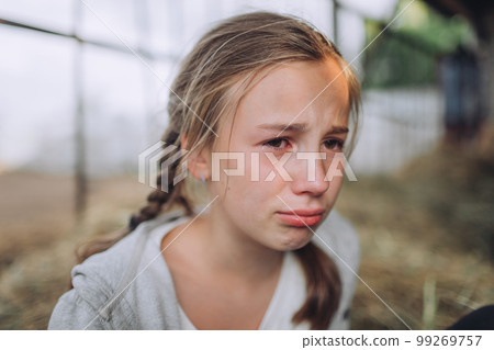 Portrait of a sad Young girl crying, tears on her face, red eyes 99269757