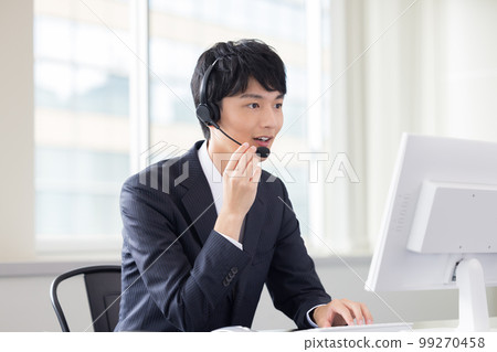 Male operator working in a business call center 99270458