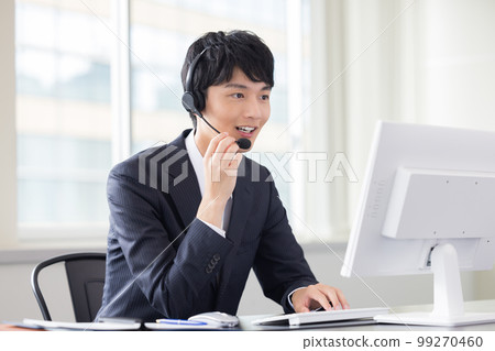 Male operator working in a business call center 99270460
