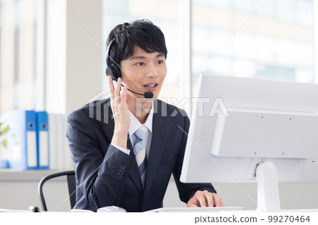 Male operator working in a business call center 99270464