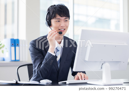 Male operator working in a business call center 99270471