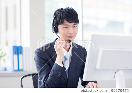 Male operator working in a business call center 99270473
