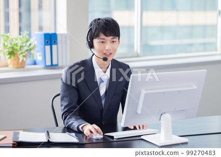 Male operator working in a business call center 99270483