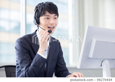 Male operator working in a business call center 99270484