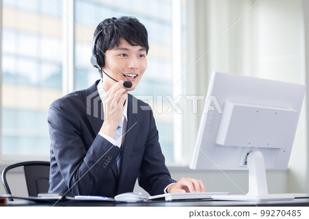 Male operator working in a business call center 99270485