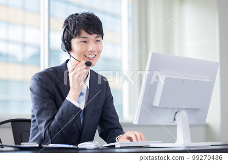 Male operator working in a business call center 99270486