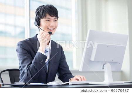 Male operator working in a business call center 99270487