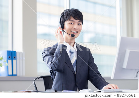 Male operator working in a business call center 99270561