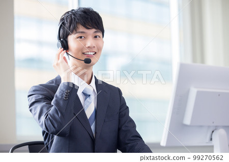 Male operator working in a business call center 99270562