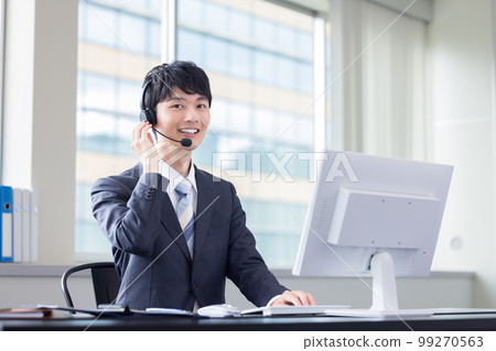 Male operator working in a business call center 99270563