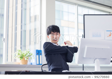 Business desk work young man stretching 99270660